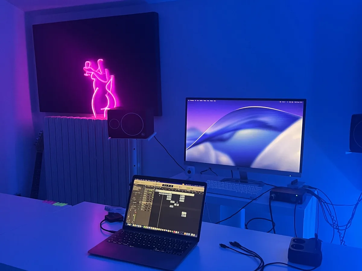 La sala di registrazione Root Studio, illuminata di blu, con monitor e postazione audio